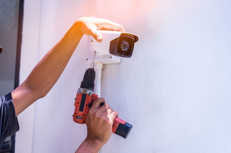 Technician installing CCTV camera for security