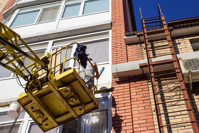 workers working with a car hydraulic lift, when working at high risk at altitude without an insurance rope, the front and rear background is blurred with a bokeh effect