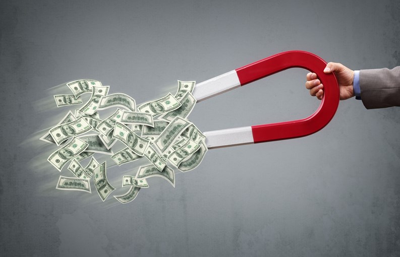 Businessman attracting money with a horseshoe magnet concept for business success, strategy or greed