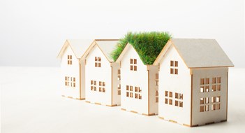 Aesthetic Rules house with green roof in among white houses for real estate property industry