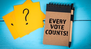 Board Elections Matter Every Vote Counts. Notebook, Pen, and Question Mark Cards on Blue Table.