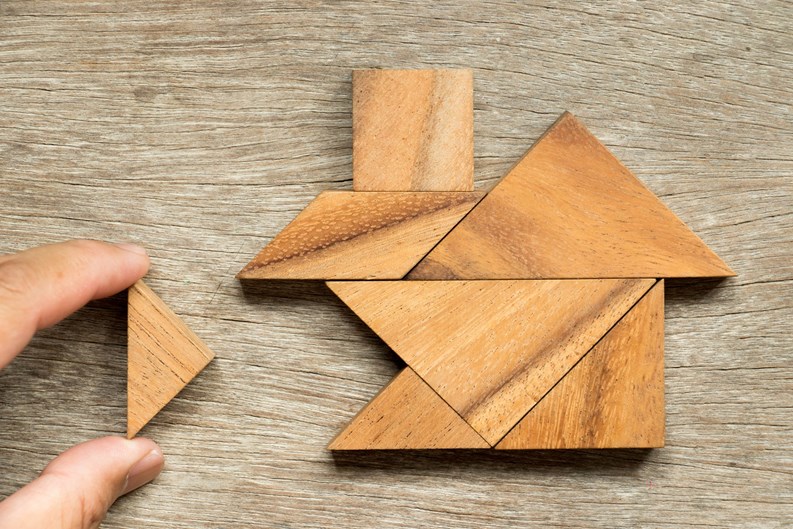 Wooden tangram puzzle in home shape wait for completion (Concept for family building or dream life)
